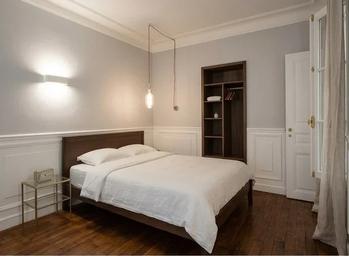 Chambre haussmannienne boiseries ivoire et parquet noyer